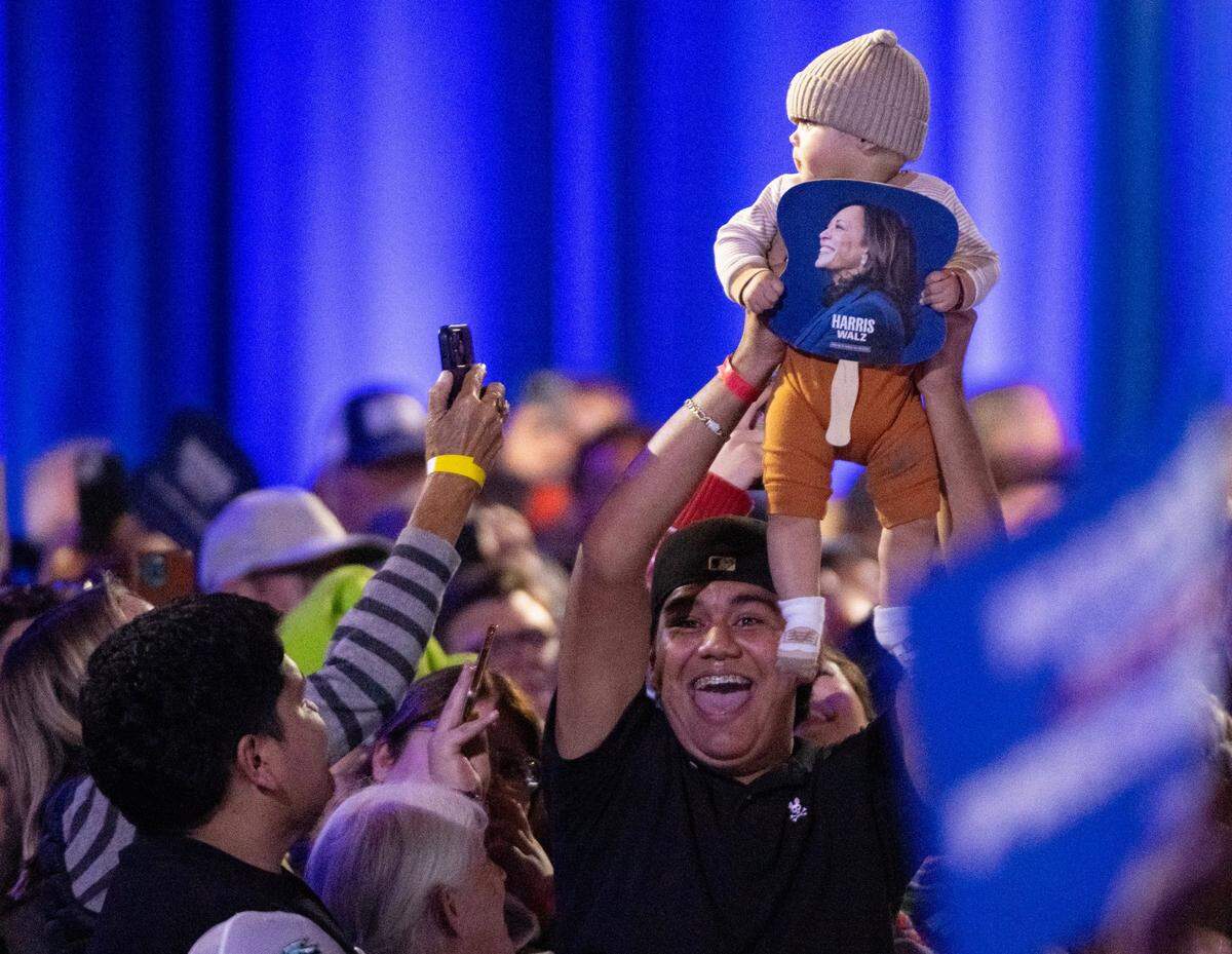 A supporter of Democratic presidential candidate Vice President Kamala Harris holds up his baby during a campaign stop at the Reno Events Center on Thursday.