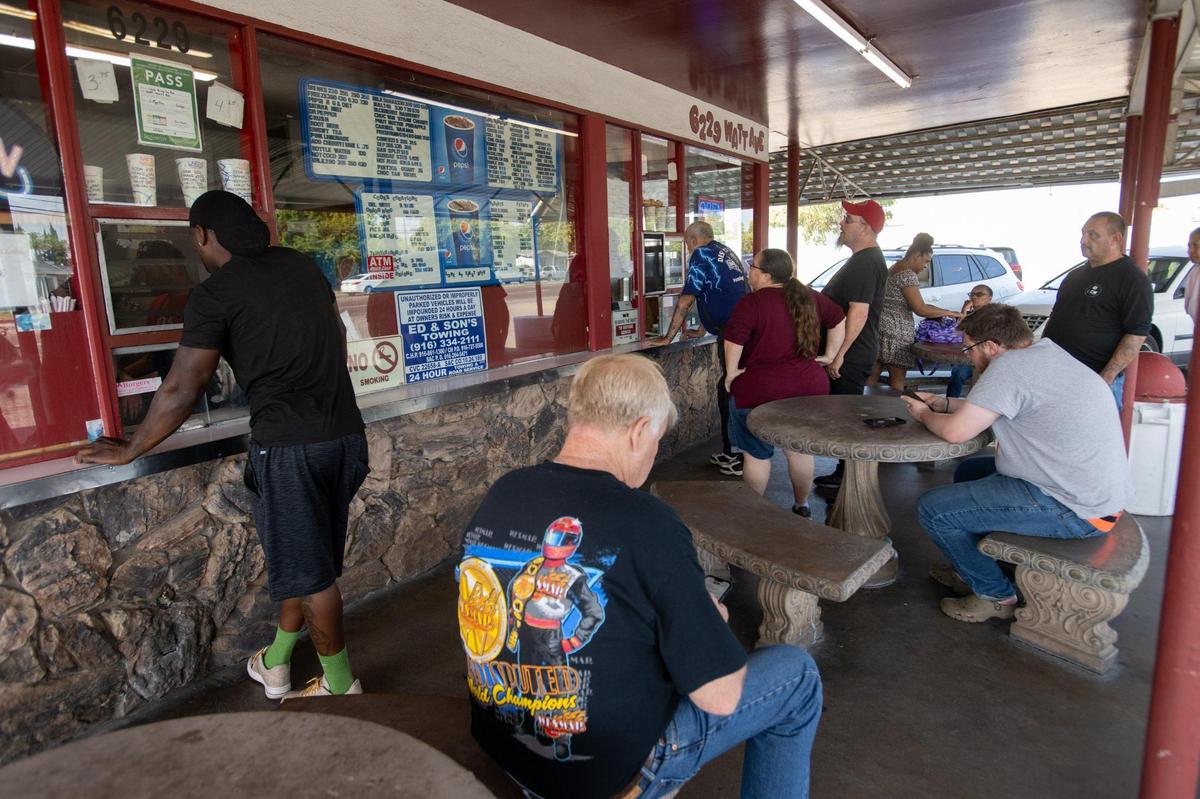 Customers wait for orders of fresh cooked food at Lou’s Burgers on Oct. 20 in North Highlands. The drive-in style restaurant opened in 1958.