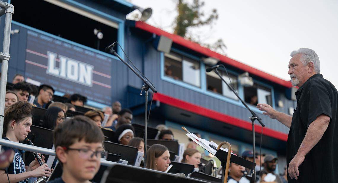 Jim “Papa” Reber, right, directs the Destiny Christian marching band before the game on Friday.