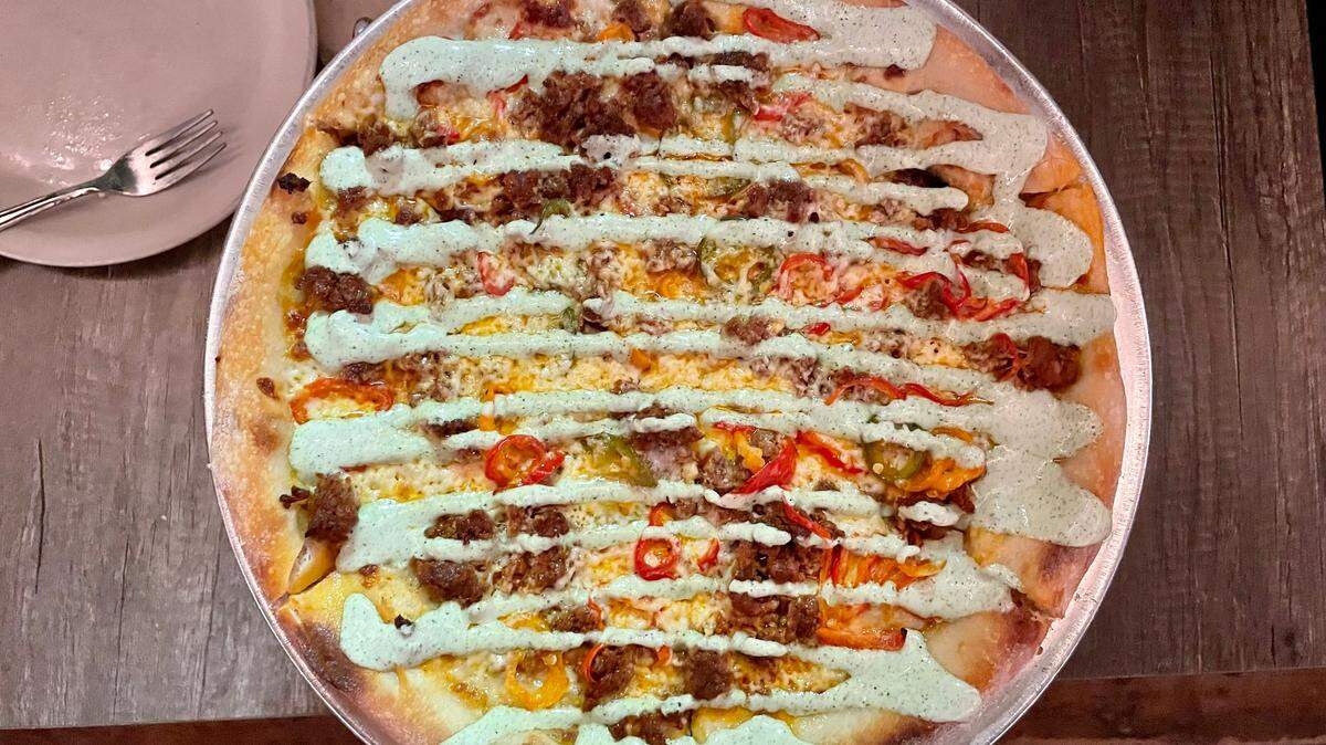 Pizzeria Luba’s Coronado pizza features chorizo, Hatch chile jack cheese, pickled peppers, roasted garlic cream sauce and an aji verde drizzle.