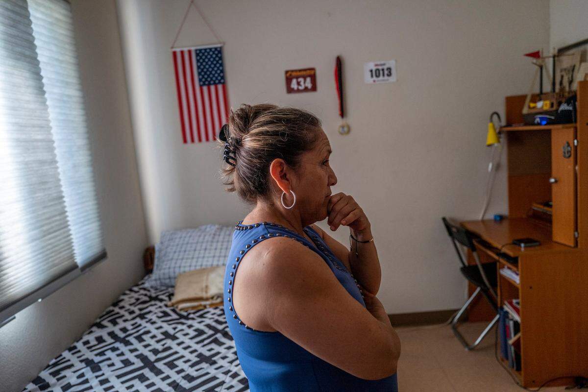 Margarita Anaya de Chavez stands inside her son’s room where an American flag and track memorabilia hang on the walls at the Davis Migrant Center in Dixon in October. She says he gets good grades and participates in sports and music at Davis High School and doesn’t want to leave the area.