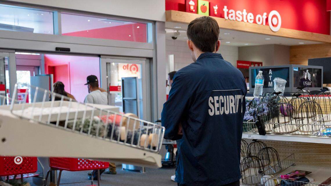 A security guard watches customers inside the Target store on Riverside Boulevard in Sacramento on Sunday, Nov. 12, 2023.
