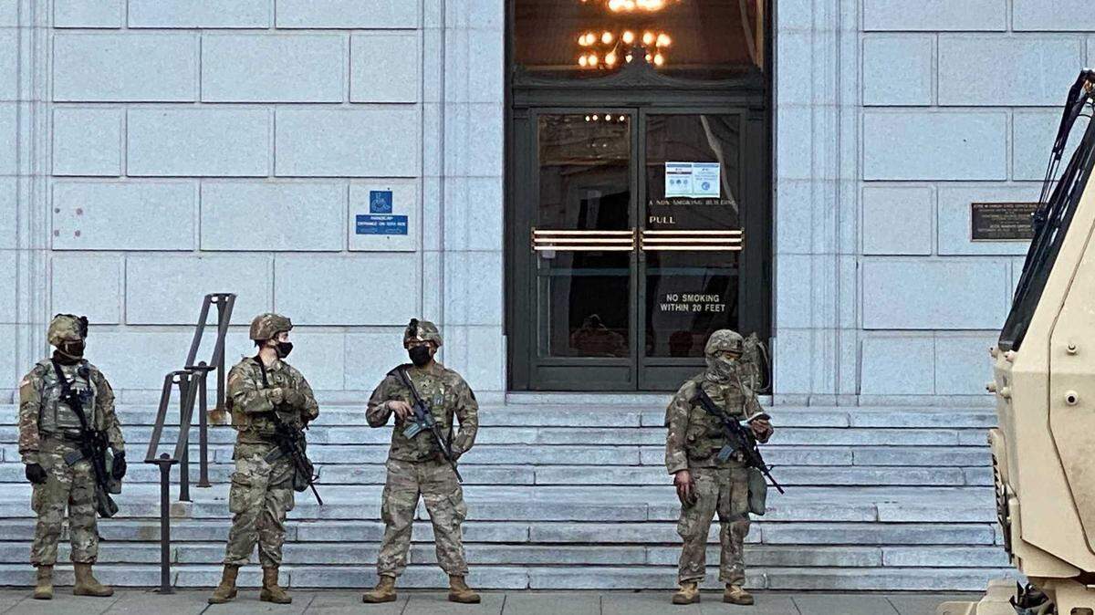 A group of National Guard personnel and equipment stand watch outside the Jesse M. Unruh State Office Building in Sacramento during the 2021 inauguration events. Gov. Gavin Newsom announced Wednesday that he would deploy the National Guard to food banks as CalFresh SNAP benefits face interruption during the federal government shutdown.