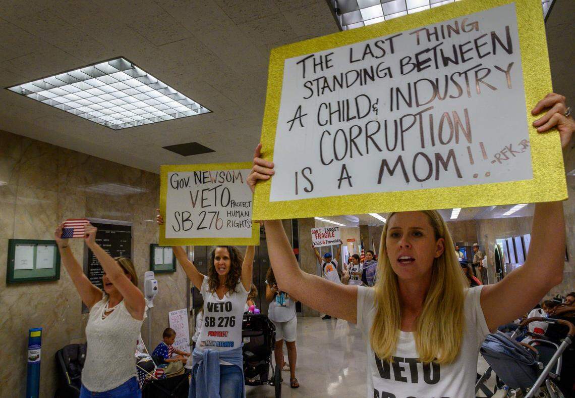 Brady Wyckoff, right, 29, a resident of San Diego, holds a sign in protest of Senate Bill 276, which eliminated the personal belief vaccination exemption in schools, outside of Gov. Gavin Newsom’s office at the Capitol in 2019.