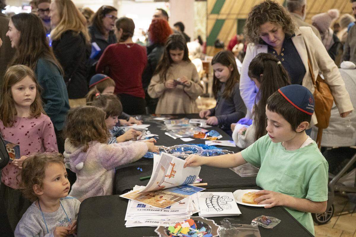 Members of the Roseville and Placer County Jewish community gather for a menorah lighting on the first night of Hanukkah at the Westfield Galleria in Roseville on Sunday.