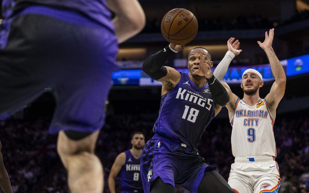 Sacramento Kings guard Russell Westbrook (18) passes the ball to center Maxime Raynaud (42) during an Emirates NBA Cup in-season tournament game as Oklahoma City Thunder guard Alex Caruso (9) defends at Golden 1 Center on Friday, Nov. 7, 2025.