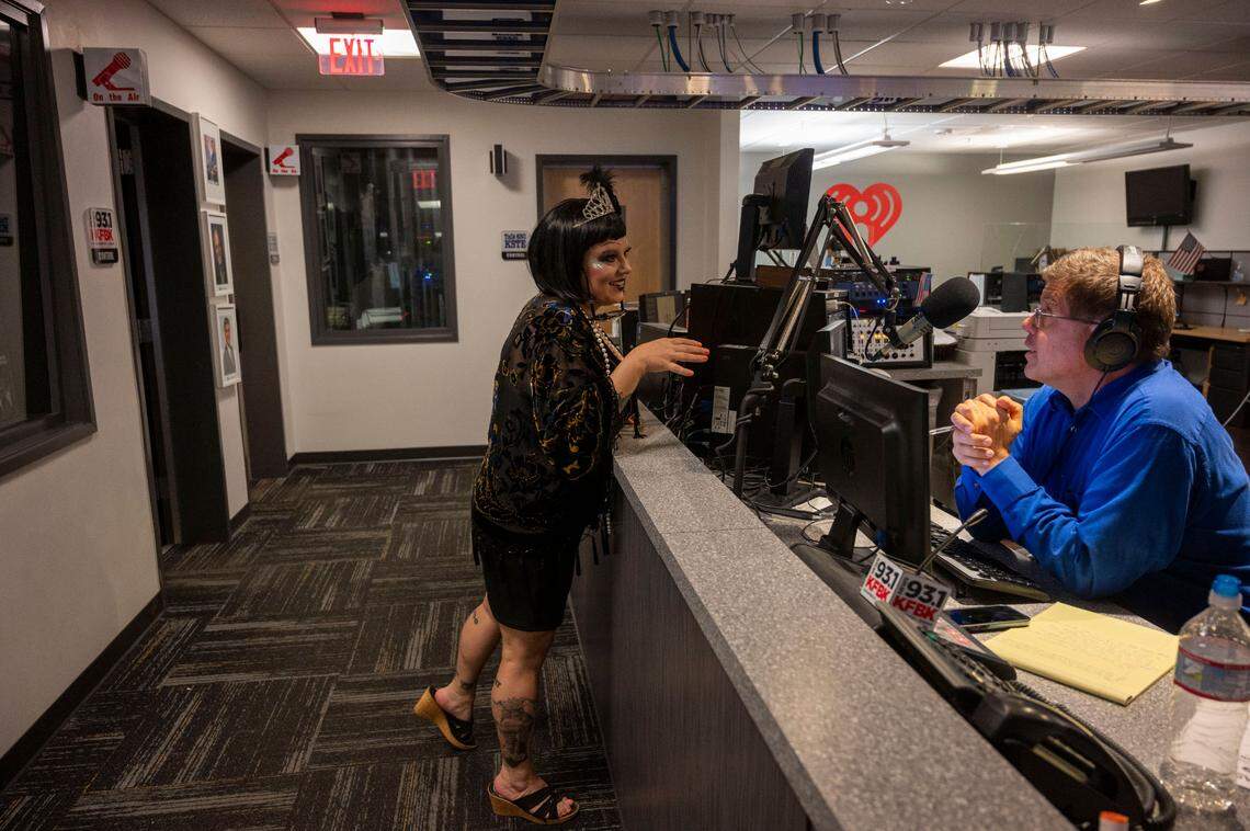 Dressed to resemble a 1920s flapper girl in honor of KFBK’s 100-year anniversay, technical producer Kendall Tobe talks with executive producer Joe Michaels on Friday, Sept. 16, 2022, at iHeart Radio in Sacramento.