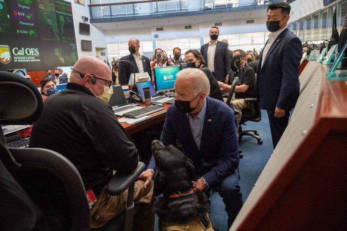 President Joe Biden greets Duce, a service dog, at the California Office of Emergency Services during a briefing on the impacts of the state’s wildfires at the OES command center at Mather Airport on Monday.