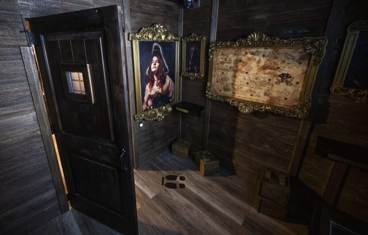 In the “A Pirates Curse” room, participants look for a hidden treasure to escape from the game at Escapology at Downtown Commons, which had its grand opening on Wednesday.