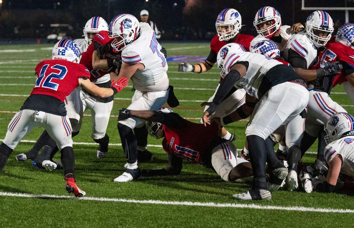 Destiny Christian Lions offensive guard Dallas Bey (77) drags several Christian Brothers defenders into the end zone for a third quarter touchdown in a Sac-Joaquin Section Division III quarterfinal game on Friday, Nov. 15, 2024, in Sacramento.