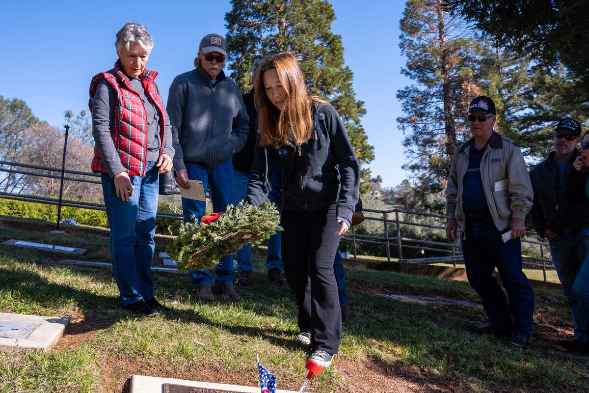 Hadley Jordan, great granddaughter of Barney Gruber, a World War II Marine veteran, lays a wreath at his burial site with her family by her side, following the Remembrance Ceremony at the Newcastle Rocklin Gold Hill Cemetery District earlier this month.