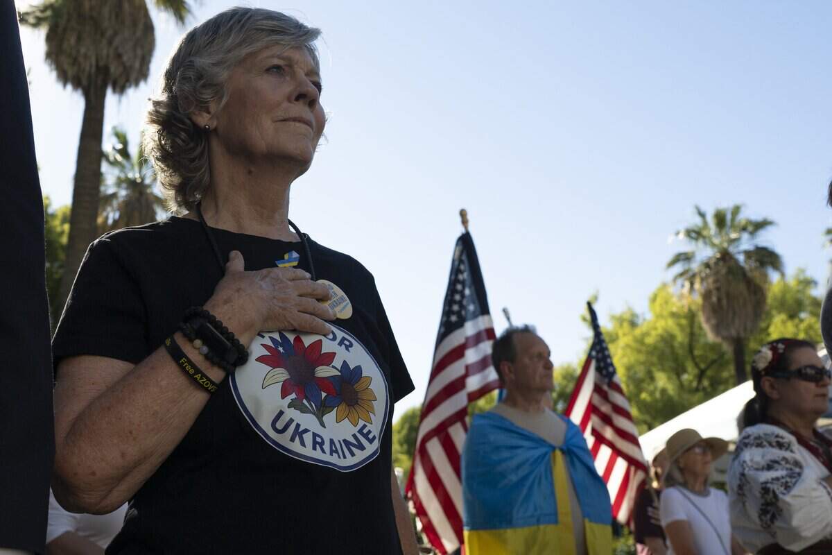 Nancy Fischer, co-founder of Yolo for Ukraine, places her hand over her heart during the singing of the United States national anthem in front of the state Capitol on Monday.