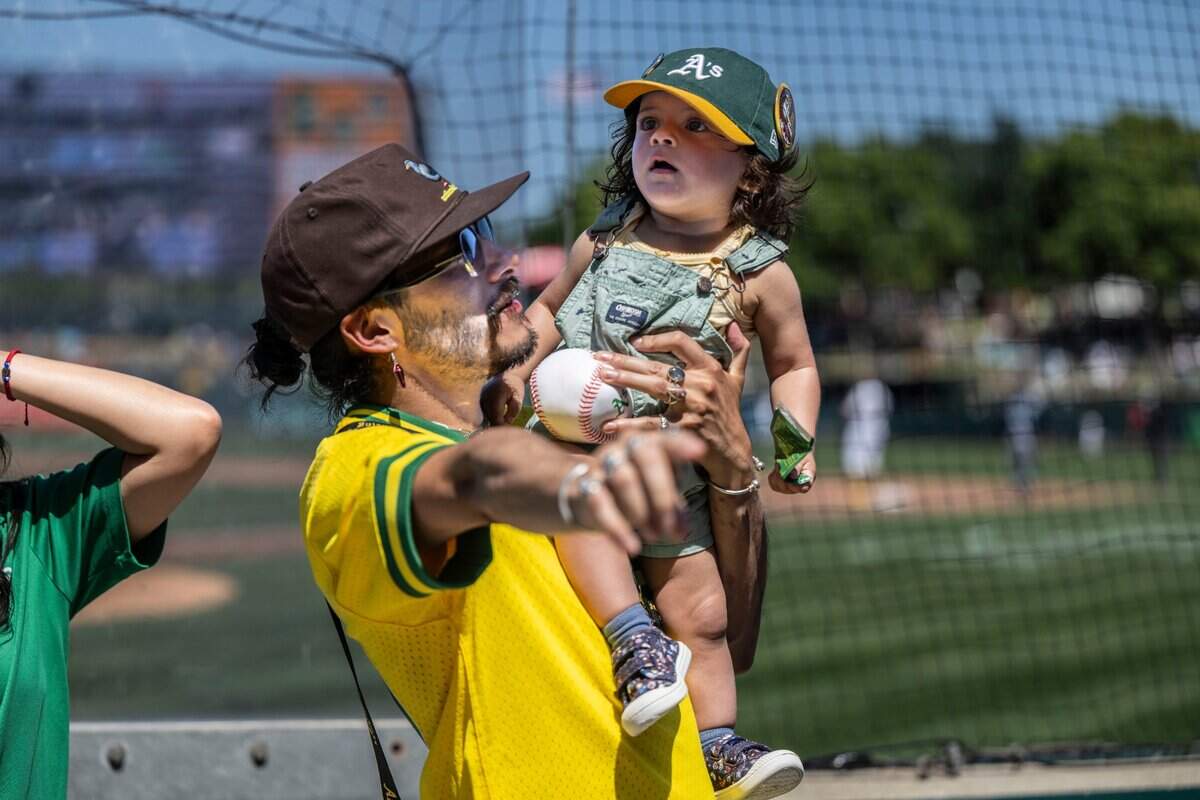 Pedro Landoni, of Berkeley, holds his daughter Camíl Landoni-Torres during a MLB between the Athletics and Seattle Mariners at Sutter Health Park on Wednesday, May 7, 2025.