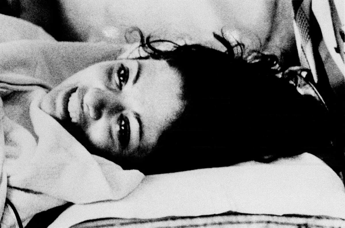 Jackie Speier, legislative assistant to slain Rep. Leo Ryan (D-Calif.), manages a smile as she is wheeled on a stretcher at Andrews Air Force Base, Md., Nov. 20, 1978. Speier, who was wounded during the attack in Guyana, was transferred from Andrews to a shock trauma unit in Baltimore, Md.