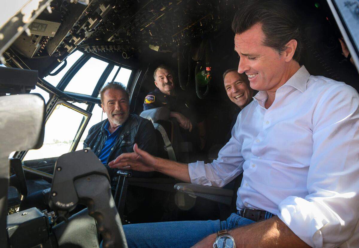 11. California Gov. Gavin Newsom, right, and former Gov. Arnold Schwarzenegger talk in a C-130 airplane cockpit with Cal Fire personnel at McClellan Air Force Base in Sacramento, Thursday, Aug. 1, 2019.