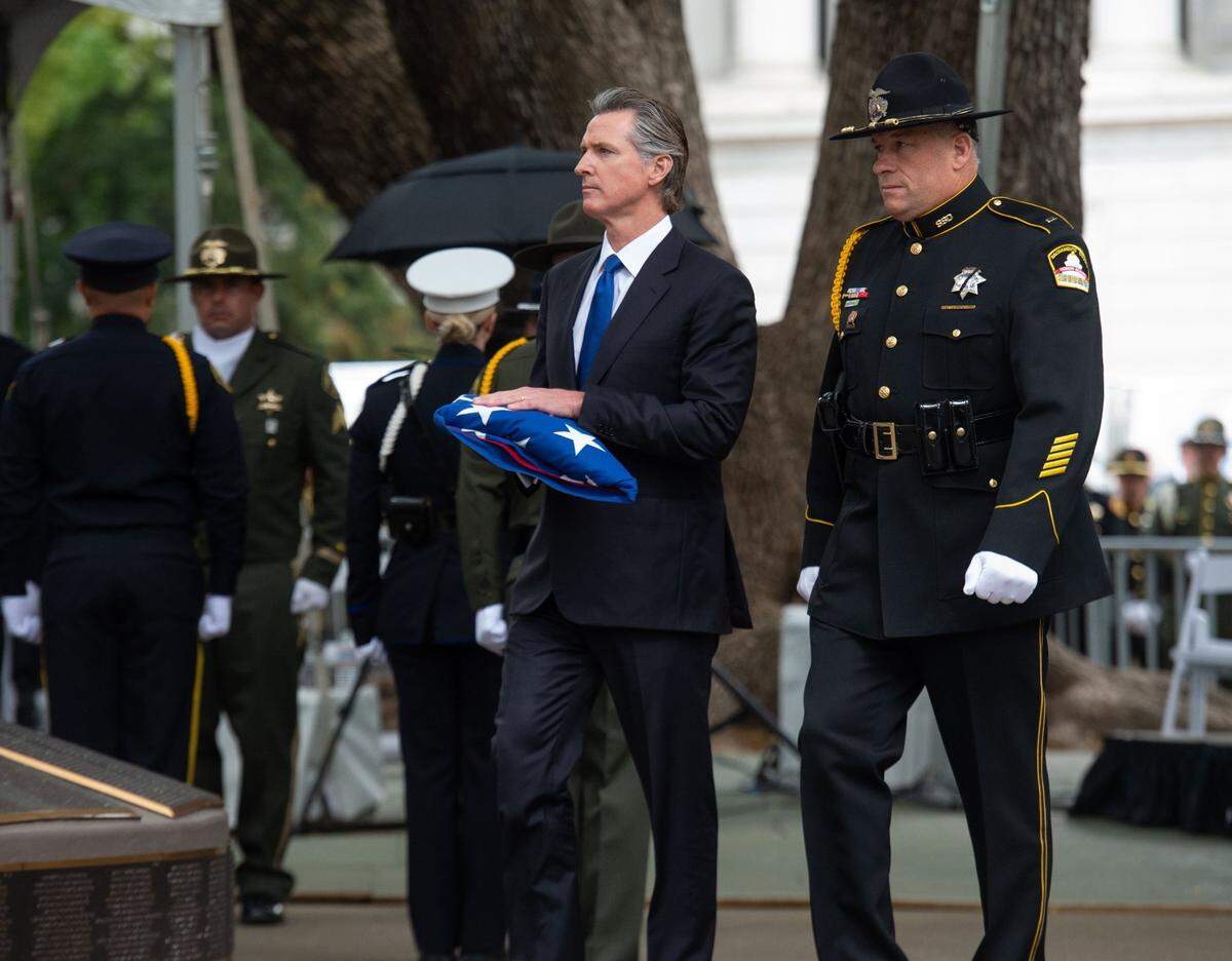 Gov. Gavin Newsom carries the flag on Monday during the California Peace Officers’ Memorial Ceremony in at the state Capitol.