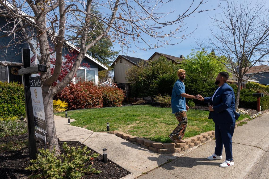 Realtor Kelly Pleasant fist bumps with homeowner Kenny Franklin at his Orangevale home that recently sold for $35,000 over the listing price with seven offers in Citrus Heights, Friday, March 18, 2022.