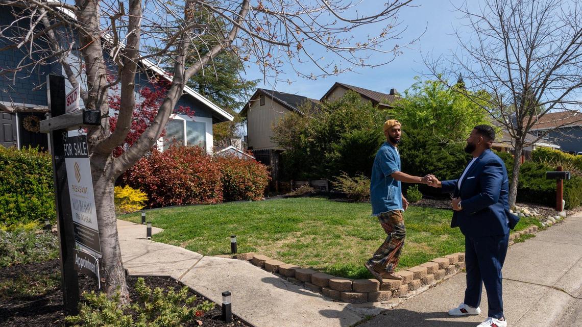 Realtor Kelly Pleasant fist bumps with homeowner Kenny Franklin at his Orangevale home that recently sold for $35,000 over the listing price with seven offers in Citrus Heights, Friday, March 18, 2022.