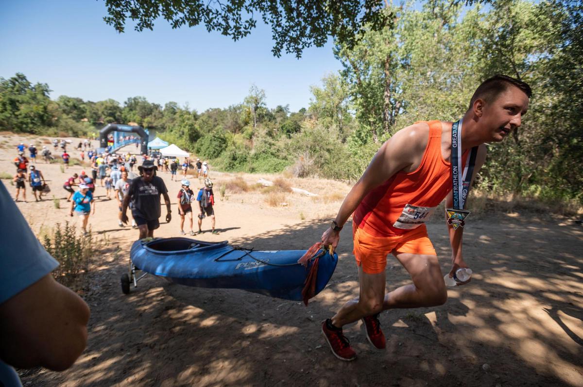 Doug Anderson, of Sacramento, hauls his kayak from the American River after competing in the Ironman open category at the Great American Triathlon, previously known as Eppie’s Great Race, on Saturday at River Bend Park in Rancho Cordova.