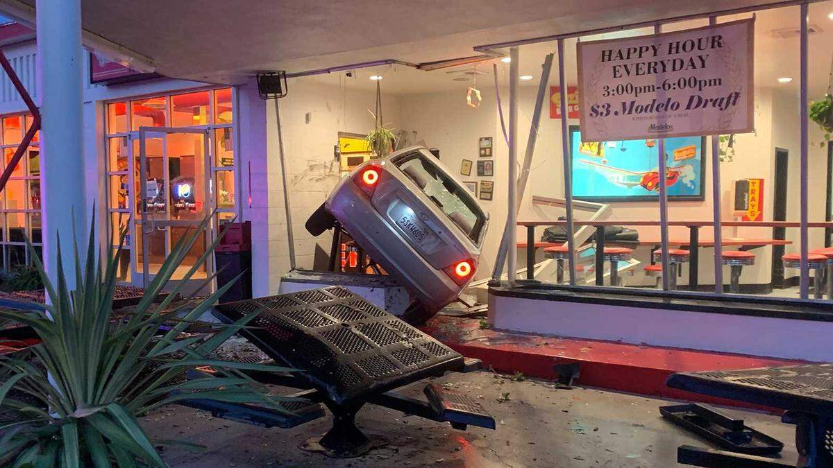 A car is seen wedged near the entrance to Suzie Burger on 29th and P streets in midtown Sacramento on Monday, Dec. 12, 2022. The driver of the vehicle was hospitalized and the cause of the crash was unknown.