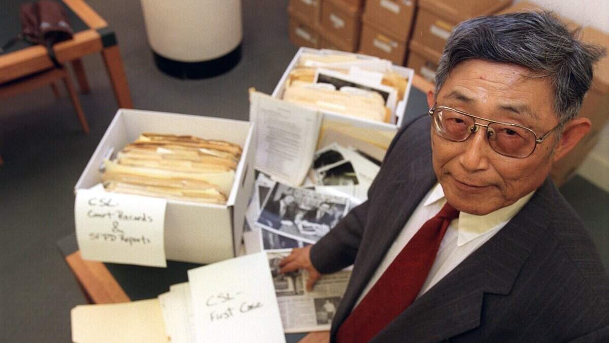 K.W. Lee stands in Shields Library at UC Davis on Oct. 8, 1997, with his original photos, newspaper articles and court records on Chol Soo Lee, a Korean American immigrant wrongly convicted of murder. Lee, known for his investigative stories that led to the acquittal of Chol Soo Lee and others, died March 8 at the age of 96.