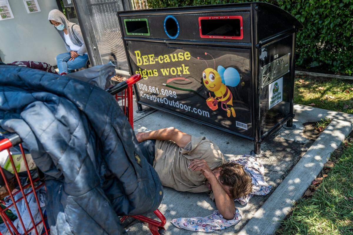 Mark Rippee shields his face from the sun while trying to take a nap in the shade at a bus stop along Markham Avenue in Vacaville last month.