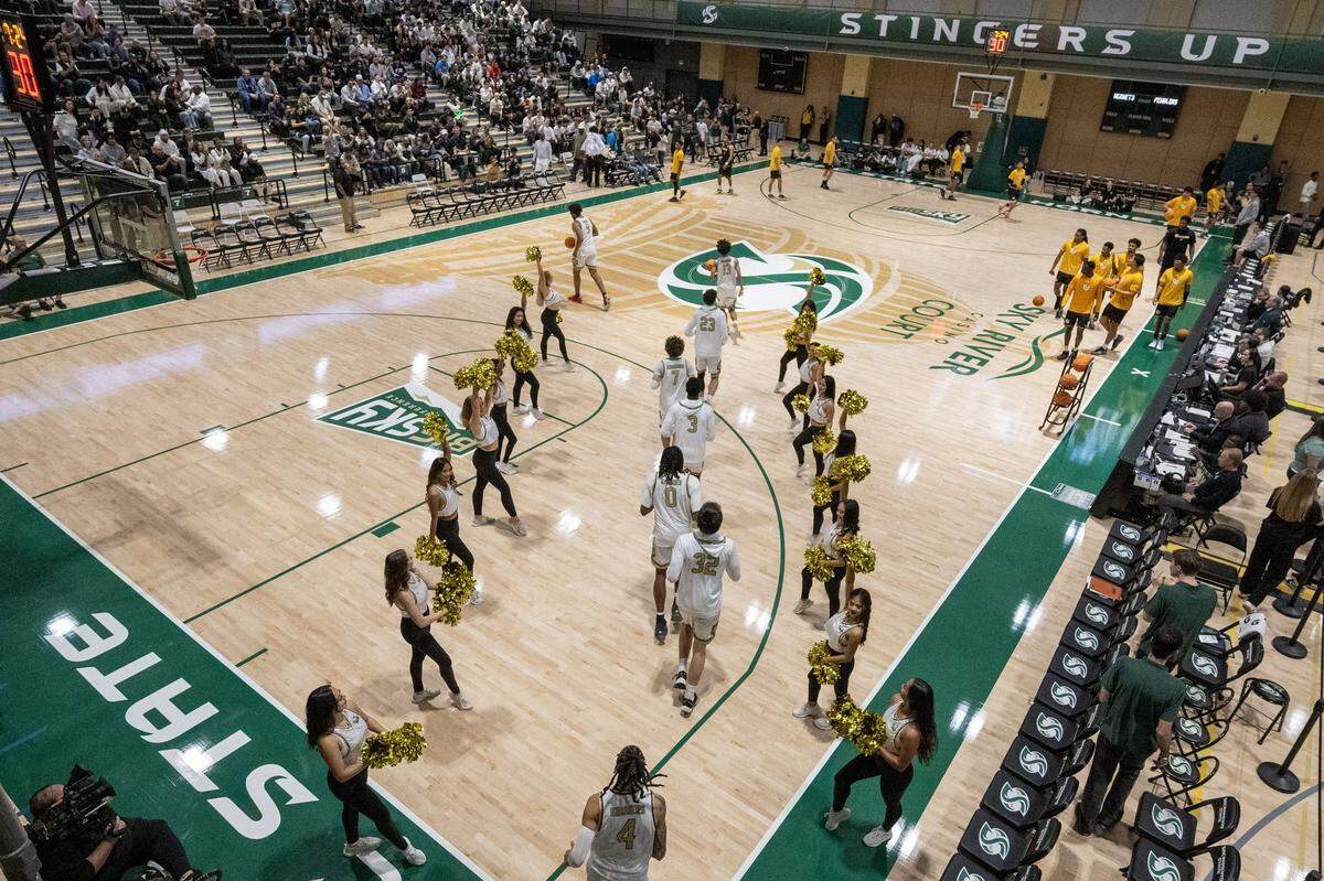 The Sacramento State men’s basketball team runs onto the court during introductions at the Hornet Pavilion against the Dominican Penguins on Tuesday in Sacramento.