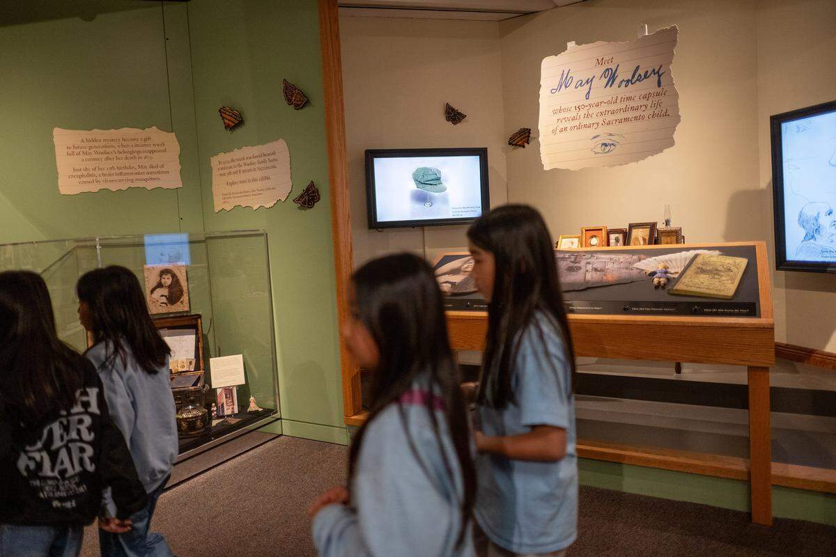 Students walk past an interactive exhibit about May Woolsey, who died in 1879 at age 12, at the Sacramento History Museum on March 27.