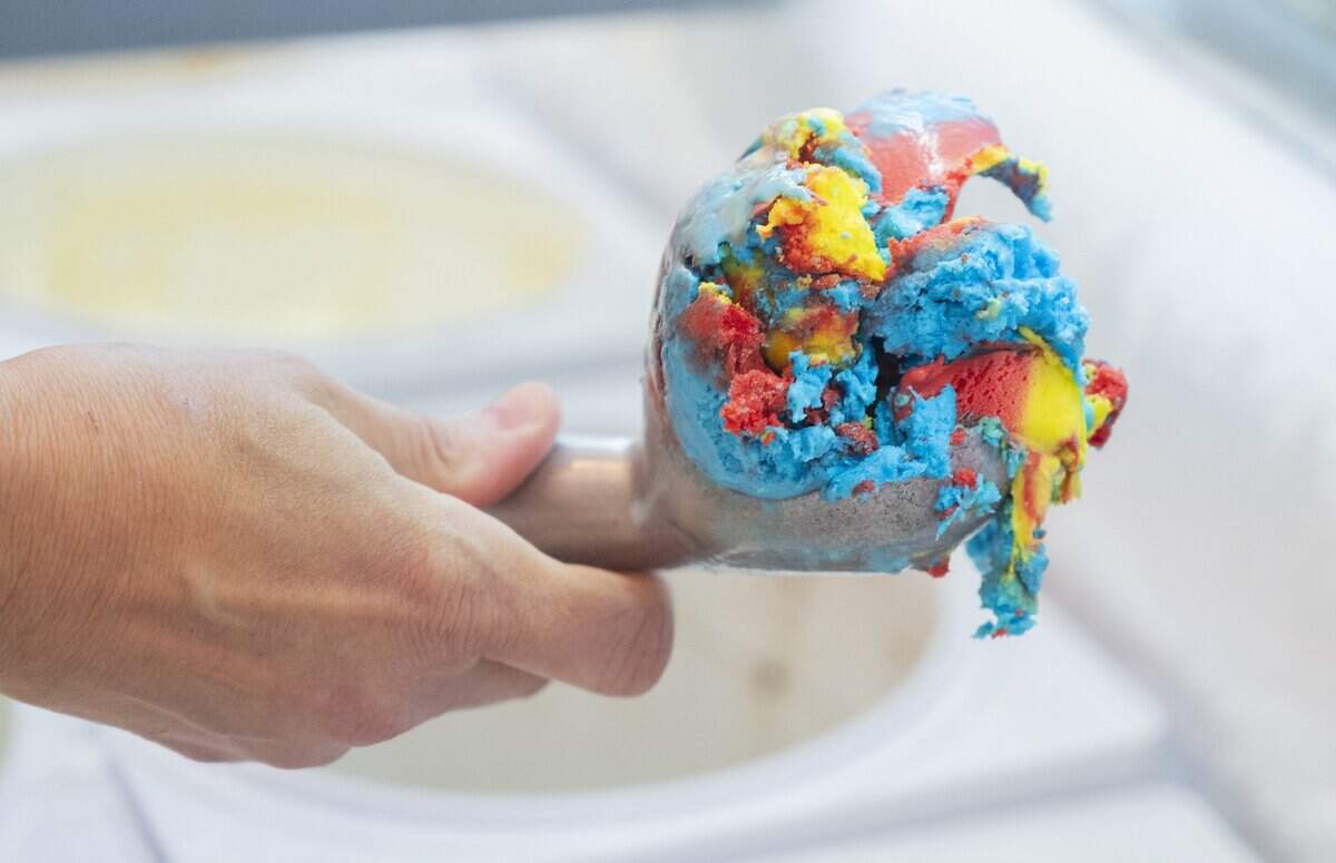 Susan Stewart, owner of Licked, scoops out a portion of Superhuman, a cherry, vanilla and fruit loop cereal milk flavored ice cream, at her shop in Sacramento on Thursday, June 11, 2026.