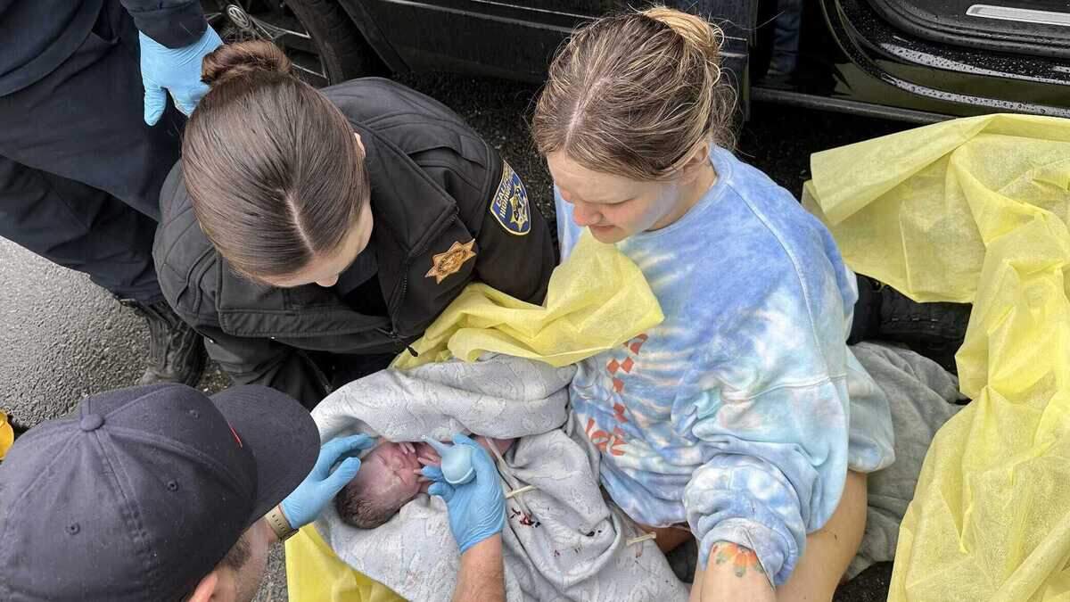 Elena Winks, far right, looks in relief as her newborn Mabel Winks is attended to by paramedics and California Highway Patrol Officer Katie Price. Elena Winks gave birth to her daughter on Interstate 80 east on March 2, 2024 in freezing rain.