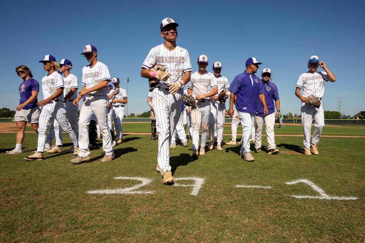 Bradshaw Christian infielder Max Wolf (22) walks past the team’s 29-1 season record marked on the grass during a first-round CIF Northern California Division IV regional baseball playoff game on Tuesday at Bradshaw Christian High School in Sacramento County.