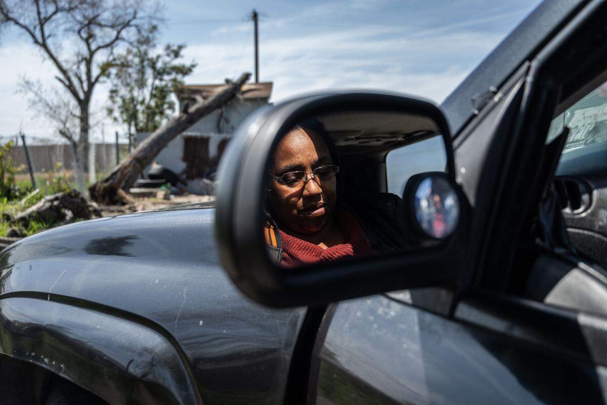 Elaine Cain, a Sacramento homeless resident, sits in her car looking at her phone as her husband sorts recyclables near the Safe Stay Community at Florin and Power Inn roads Wednesday. “Driving by here, you have everyone in the fields behind it, in front of it, on the side of it,” she said. “It’s very discouraging.”