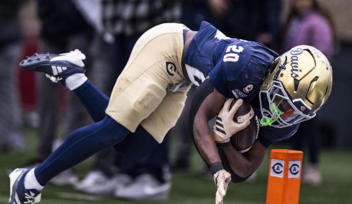 UC Davis Aggies running back Jordan Fisher (20) falls into the end zone for his team’s first touchdown in the first quarter during an FCS playoff quarterfinal at UC Davis Health Stadium on Saturday.