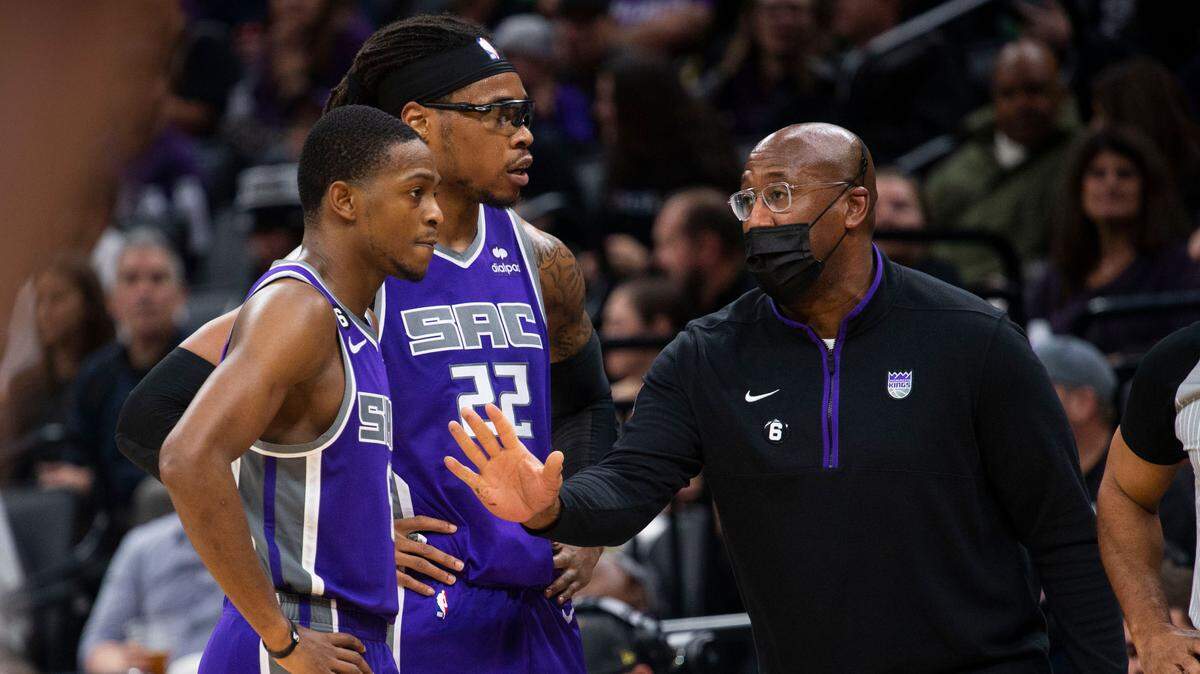 Sacramento Kings guard De’Aaron Fox (5) and teammate center Richaun Holmes (22) listen instructions from coach Mike Brown as they play against the Utah Jazz on Friday, Dec. 30, 2022 during an NBA basketball game at Golden 1 Center in Sacramento.