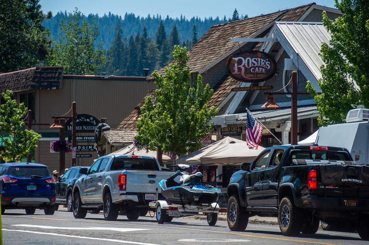 Vehicles – including a personal watercraft – fill North Lake Boulevard in front of Rosie’s Cafe in Tahoe City on July 13. High housing costs have made it difficult for local businesses to recruit enough workers to fully reopen in the the popular summer and winter recreational area. 