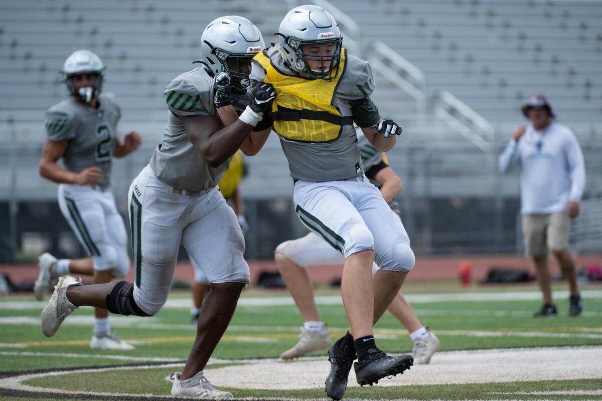 Granite Bay football players Bryan Bogne, left, and Kyle Becwar (81) run a drill at the high school in Granite Bay on Wednesday, Aug. 17, 2022. Teams are reducing contact in practices to avoid injuries and concussions.