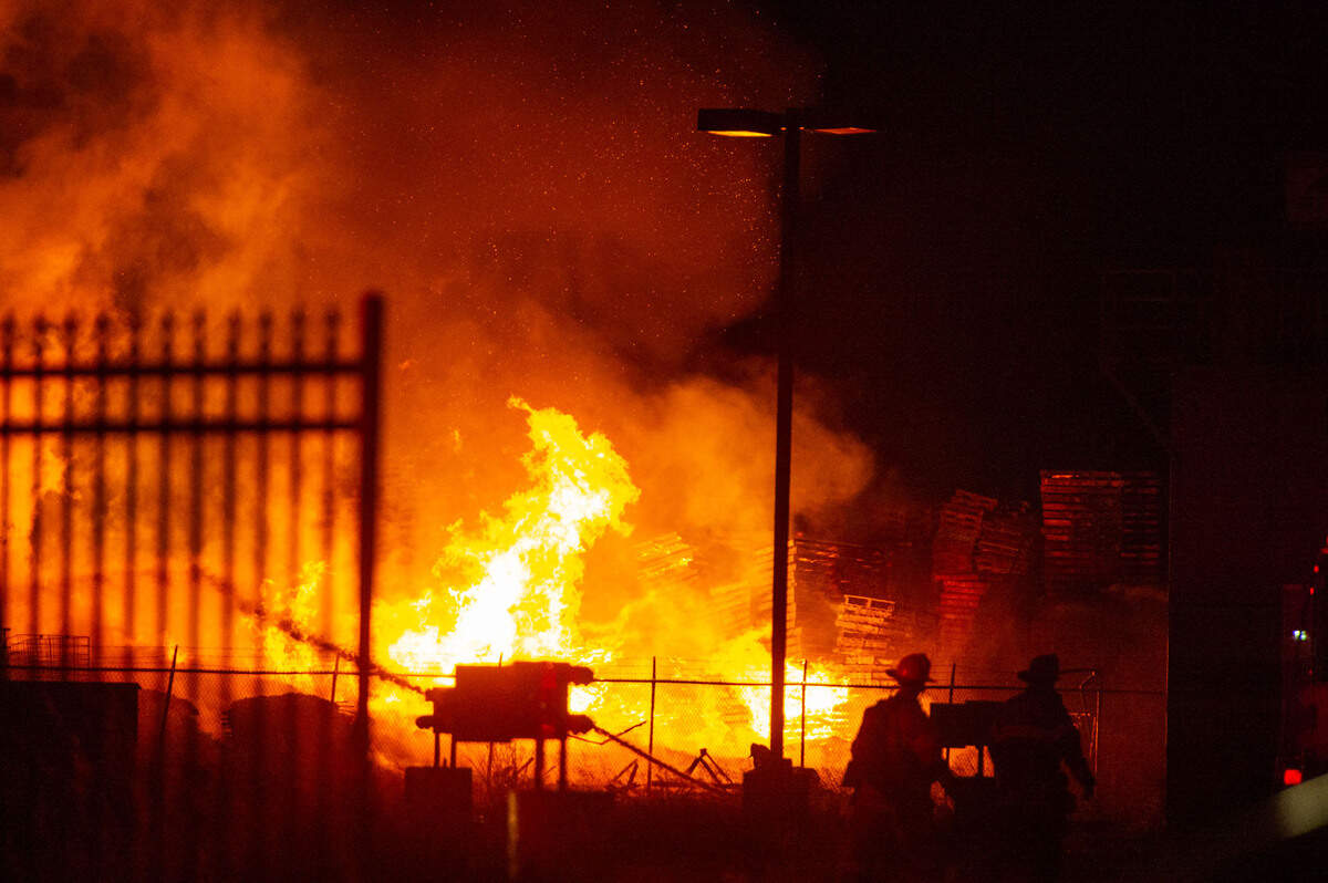 Firefighters battle a large pallet fire in an industrial section of Sacramento on Tuesday night, May 31, 2022.