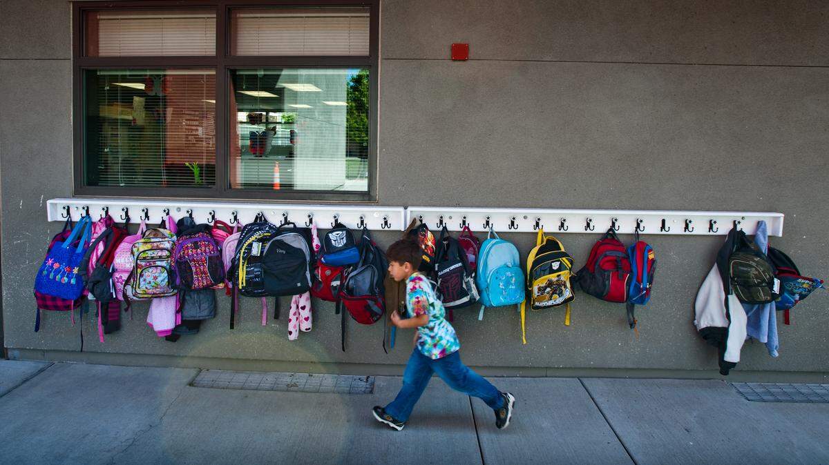 JUMP LEDE Five-year-old Liam Muller <cq> runs through a line of hook holding his fellow student’s backpacks Heron Elementary school. A parent installed the hooks because space was limited in the classroom according to kindergarten teacher Georgia Schaff <cq> at Heron Elementary who has 27 kindergarten students, up from 20 and expects more than 30 kindergarteners next school year. The Natomas Unified School District says = class sizes could go up even higher next school year. School districts throughout the region are throwing class size reduction out the window and paying penalties, which they say now are cheaper than keeping teachers they can’t afford. April 16, 2010