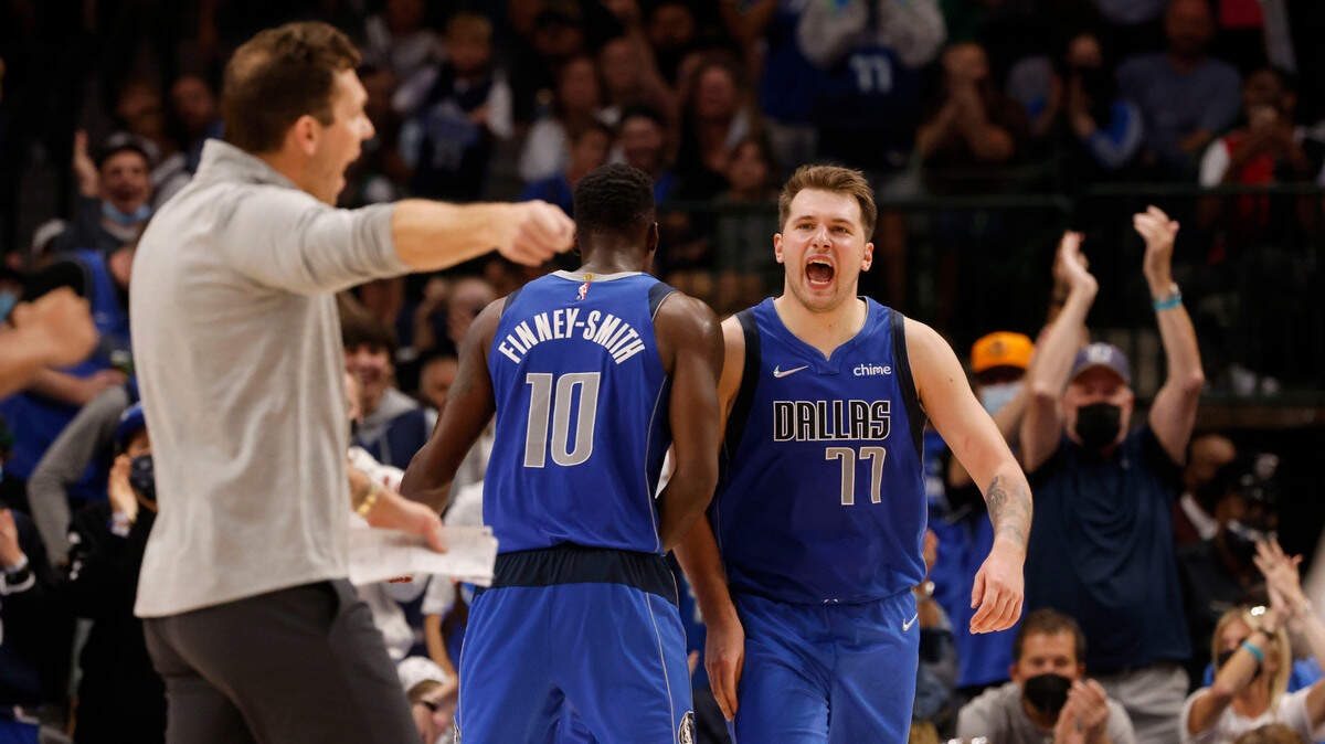 Dallas Mavericks forward Dorian Finney-Smith (10) and guard Luka Doncic (77) celebrate a basket as Sacramento Kings head coach Luke Walton, left, complains to the referees during the second half of an NBA basketball game in Dallas, Sunday, Oct. 31, 2021. (AP Photo/Michael Ainsworth)