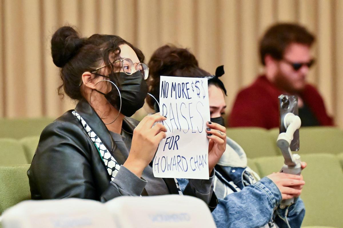 A woman holds up a sign opposing a raise for Sacramento City Manager Howard Chan at the council meeting on Tuesday, Jan. 9, 2024.