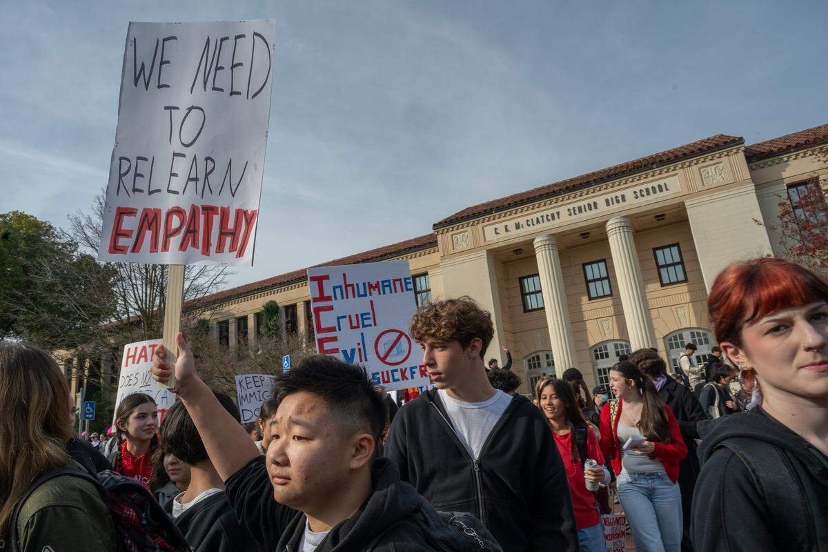 Skylar Lam holds a “We need to relearn empathy” sign as he joins McClatchy High students who took part in a districtwide walkout on Friday in Sacramento, joining a nationwide effort to protest immigration enforcement following fatal shootings in Minneapolis.