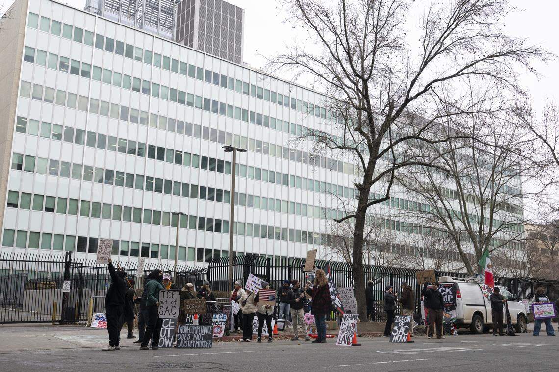 Anti-ICE protesters wave signs outside the John Moss Federal Building in Sacramento on Sunday. Protesters have been protesting outside the building on and off for months since Immigration and Customs Enforcement started detaining immigrants in the building.