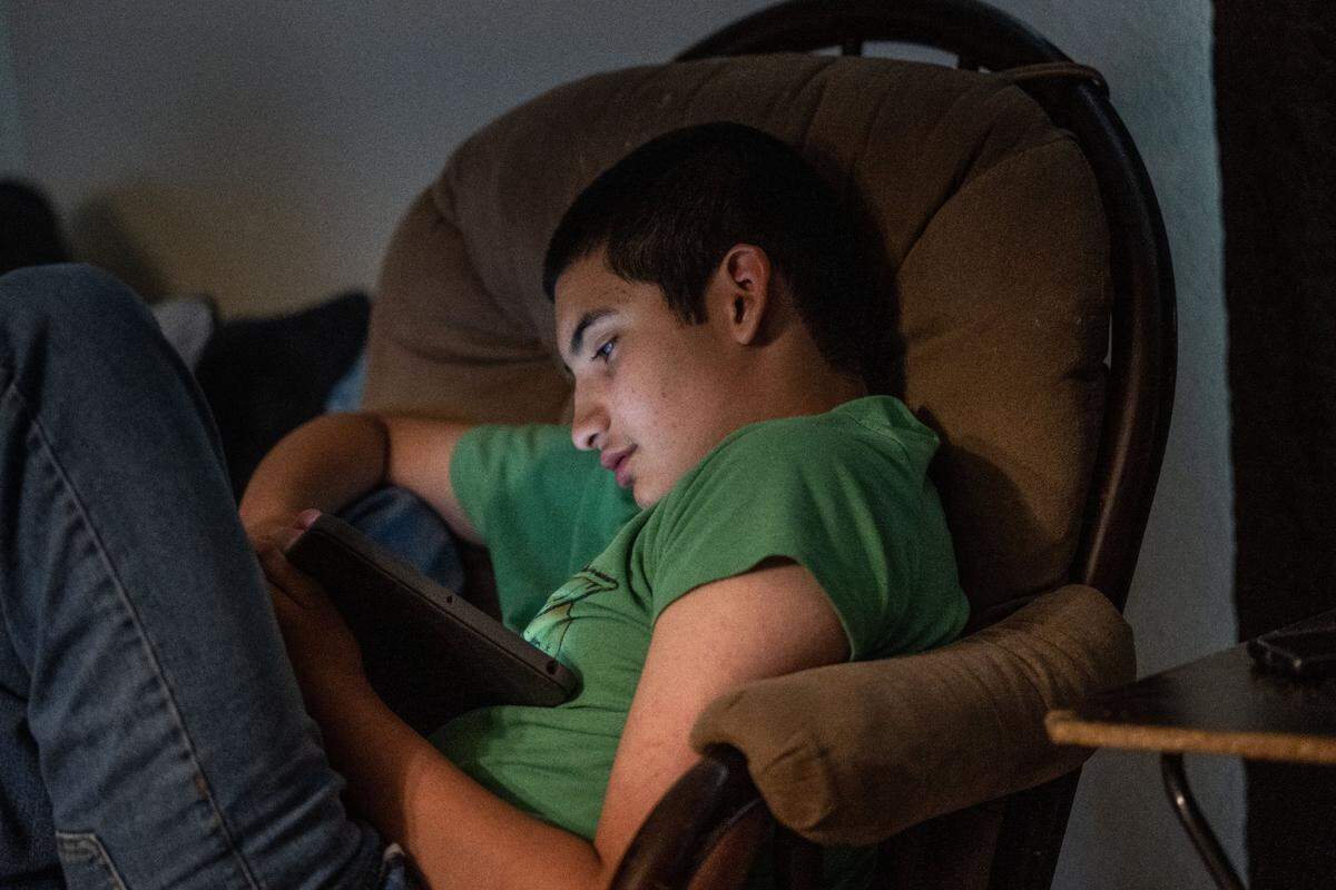 Max Moran Soto, 14, who was diagnosed at age 3 with autism and attention deficit hyperactivity disorder, looks at a video on his tablet at home in Manteca in August. Max’s mother Ana Soto said she fought to get the support he needed and feels he would have benefited from receiving special education services from a younger age.