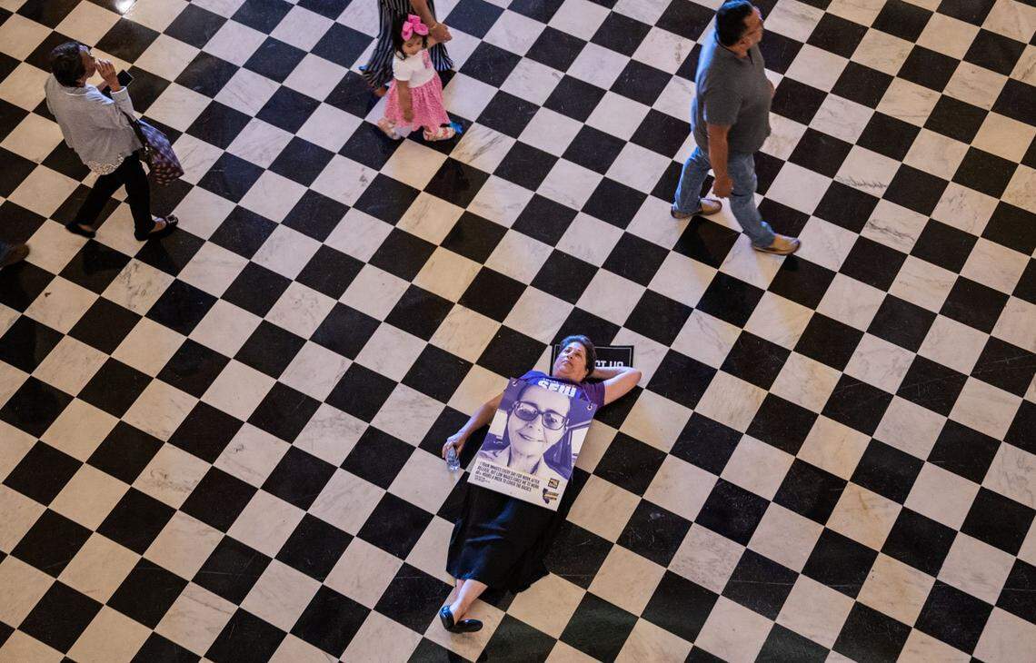 Francesca Wander, of Sacramento who works for the California State Department of Housing lays on the floor in the rotunda at the Capitol in protest Thursday during the SEIU Local 1000 silent march to draw attention to their fight for higher pay.