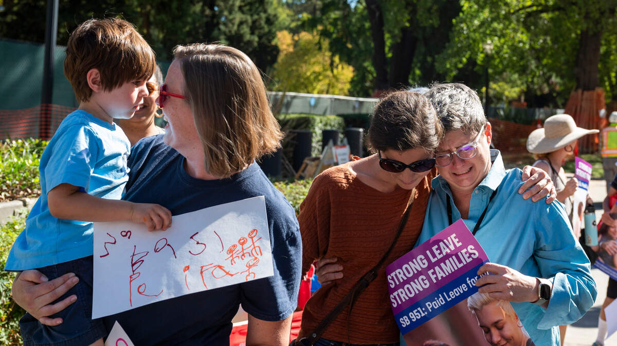 Jennifer Richard, right, chief of staff to state Sen. Elena Durazo, has an emotional response in 2022 after announcing amid a crowd of bill supporters that Gov. Gavin Newsom had signed Senate Bill 951. The bill will expand access to California’s paid family leave program by increasing the amount paid to lower-wage employees who use the system. 