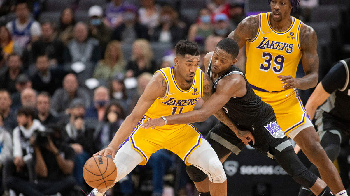 Los Angeles Lakers guard Malik Monk (11) dribbles the ball as Sacramento Kings guard De’Aaron Fox defends during the second half of an NBA basketball game in Sacramento, Calif., Tuesday, Nov. 30, 2021. The Lakers won 117-92. (AP Photo/Randall Benton)
