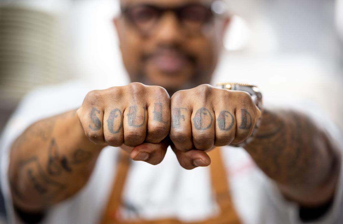 Executive Chef Melvin “Boots” Johnson, originally of Compton and recently from New York City, is committed to soul food, as evidenced in his hand tattoos shown in the kitchen at Fixins Soul Kitchen on Tuesday, Dec. 10, 2019, in Sacramento’s Oak Park neighborhood.