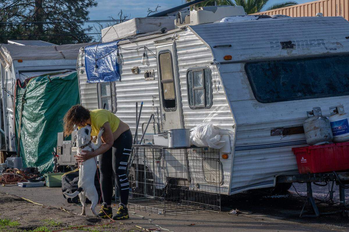 Nicole Stuart seeks comfort in her dog Zenvader outside her trailer in North Sacramento on Dec. 21. The group was notified they might be swept and she was concerned about her dogs if she couldn’t tow her trailer.