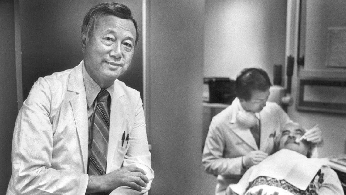 Dr. Herbert Yee in his downtown Sacramento dental office in 1986. Yee, a leader in the Chinese community, practices with two of his sons. One of them, Dr. Wesley Yee, attends to a patient in the background.