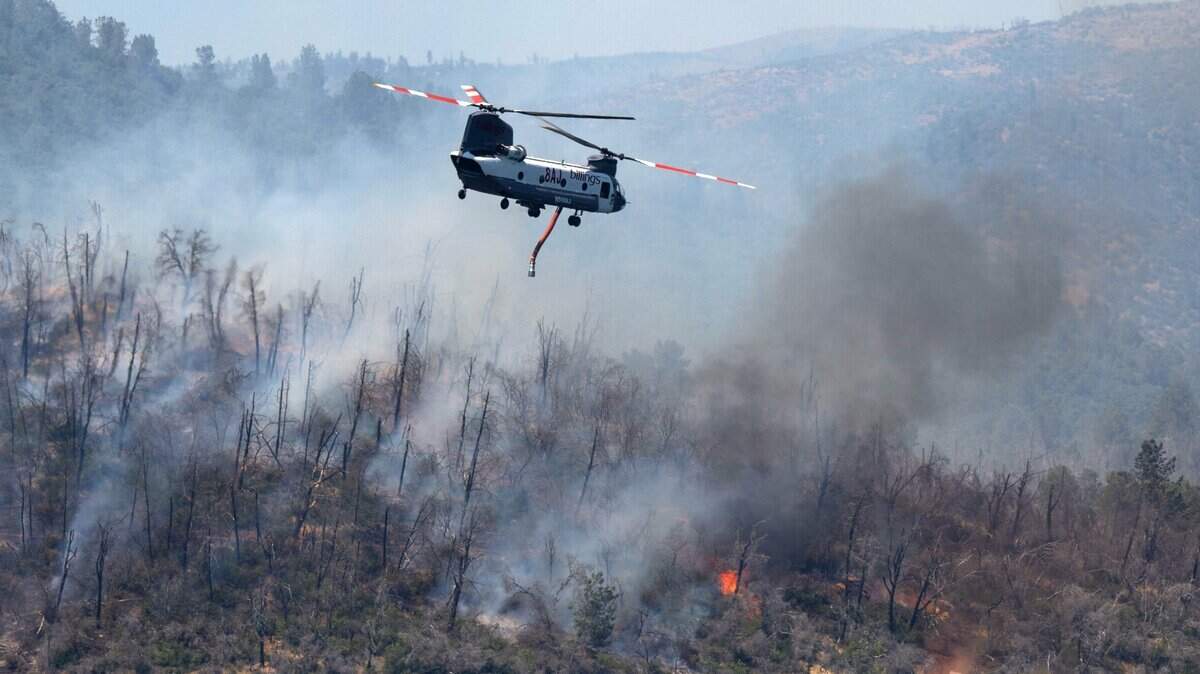 A helicopter flies over the Thompson Fire near the Oroville Dam on Wednesday, July 3, 2024.